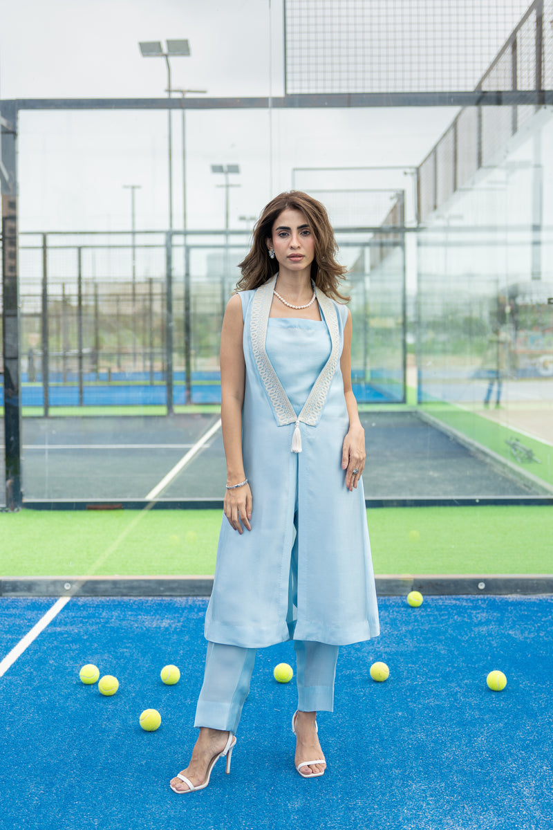 Pearl white Dori embroidery on ice blue silk cape paired with straight pants.